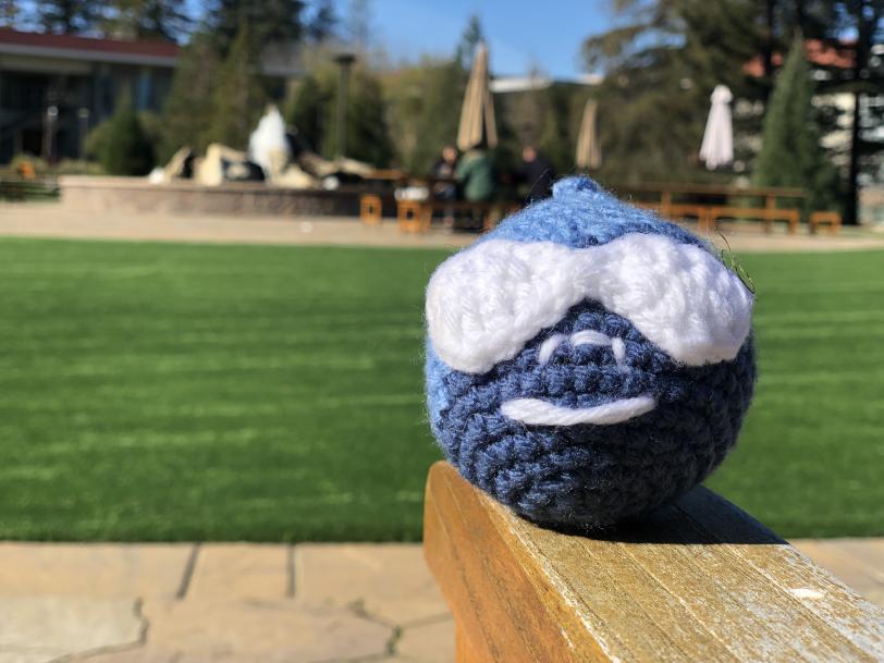 knitted Drupal logo sitting on park bench in SLAC's main quad